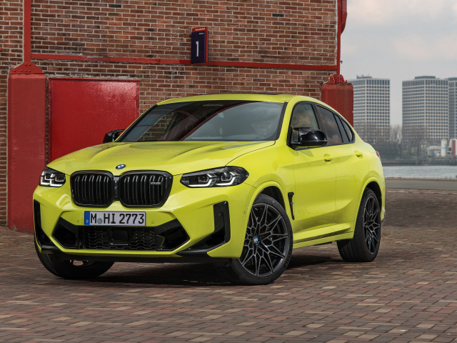 Желтый автомобиль BMW X4 M Competition 2021 года у стены