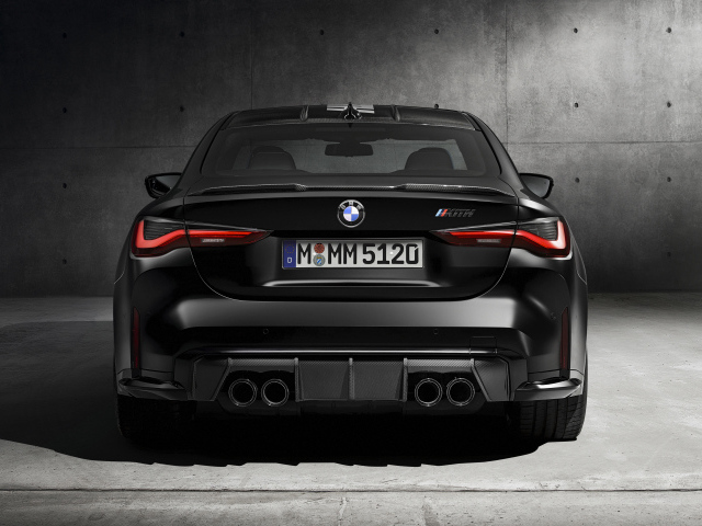 Черный BMW M4, 2021 года вид сзади на сером фоне