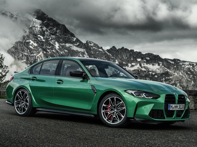 Зеленый автомобиль BMW M3 Competition 2020 года на фоне горы