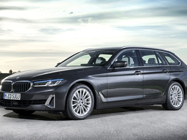 Серебристый автомобиль BMW 530d XDrive 2020 года на дороге 