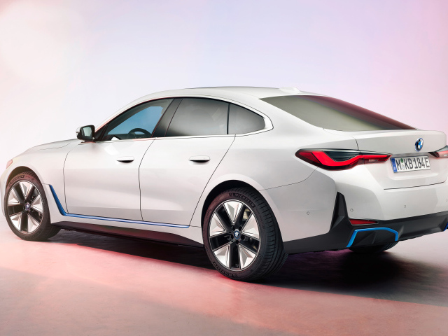 Белый автомобиль BMW I4 2021 года на розовом фоне