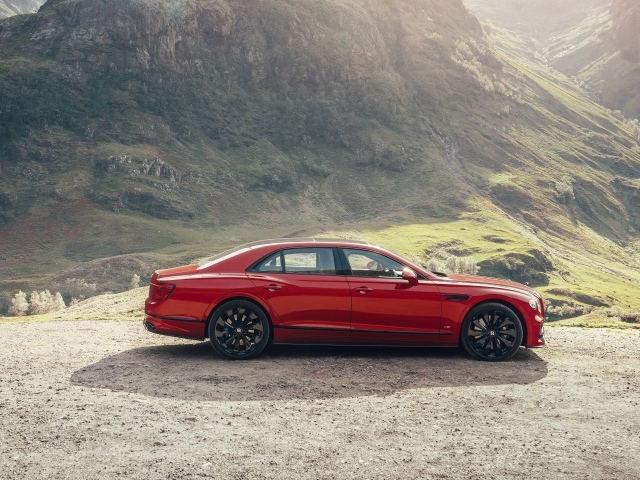 Красный автомобиль Bentley Flying Spur V8 2020 года у горы 