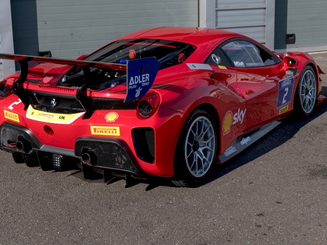 Красный спортивный Ferrari 488 Challenge Evo 2020 года у гаража 