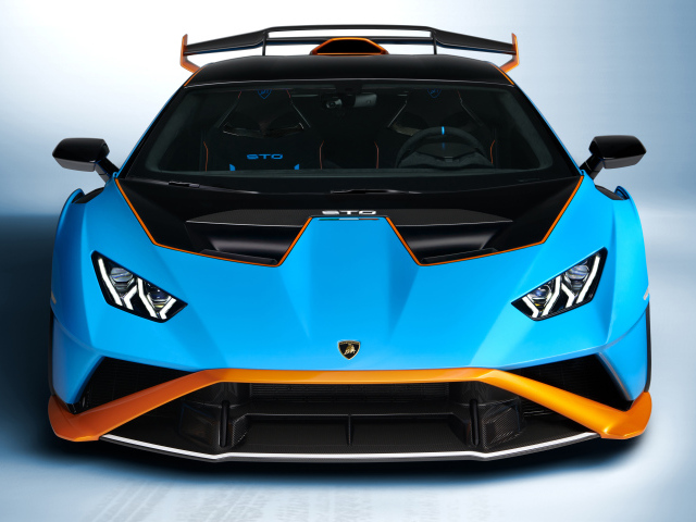Голубой автомобиль Lamborghini Huracán STO 2021 года вид спереди на сером фоне