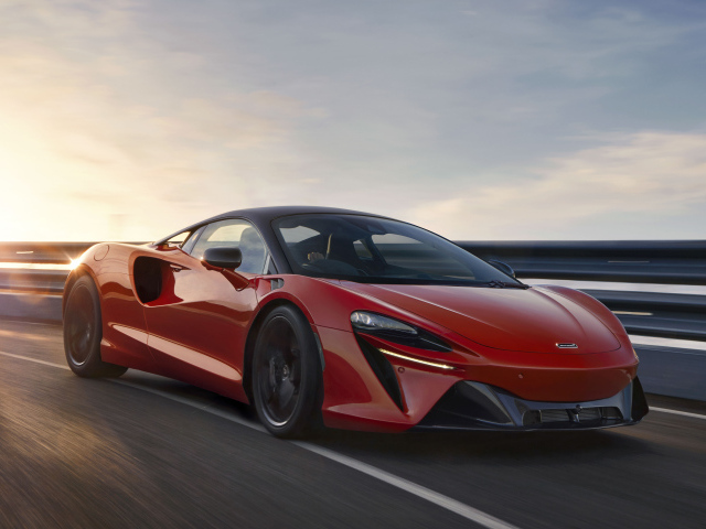 Красный быстрый автомобиль McLaren Artura, 2021 года на трассе