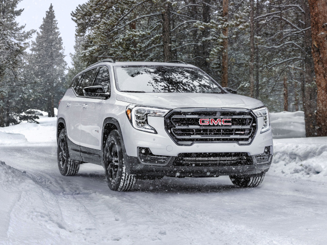 Большой белый внедорожник GMC Terrain AT4, 2022 года на снегу