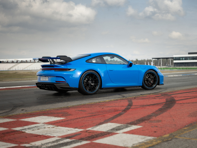 Голубой автомобиль  Porsche 911 GT3 2021 года на трассе