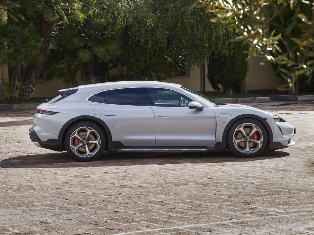 Серебристый автомобиль Porsche Taycan 4S Cross Turismo 2021 года у дома