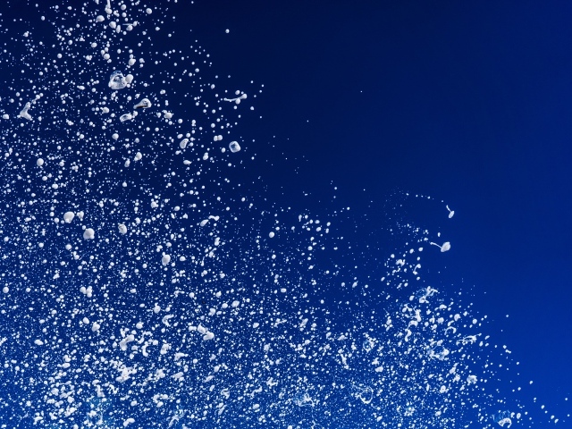 Белые брызги воды на синем фоне 