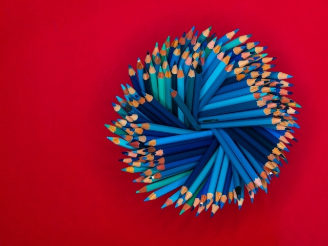 Синие карандаши на красном фоне