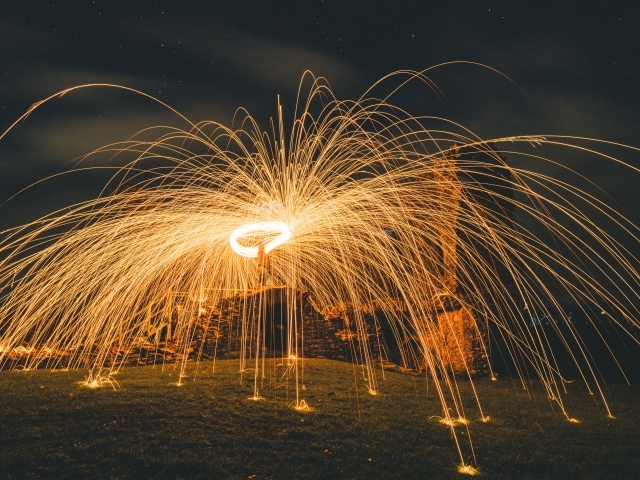 Яркие огненные искры фейерверка на развалинах