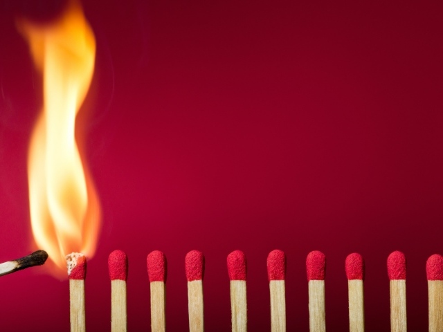 Спички поджигают на красном фоне