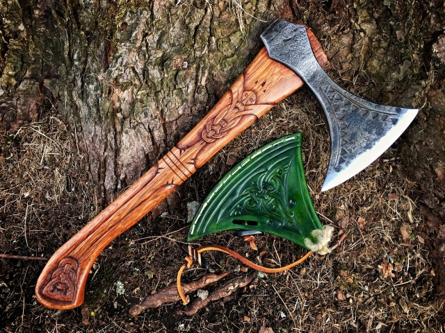 Старый топор с рисунком у дерева 