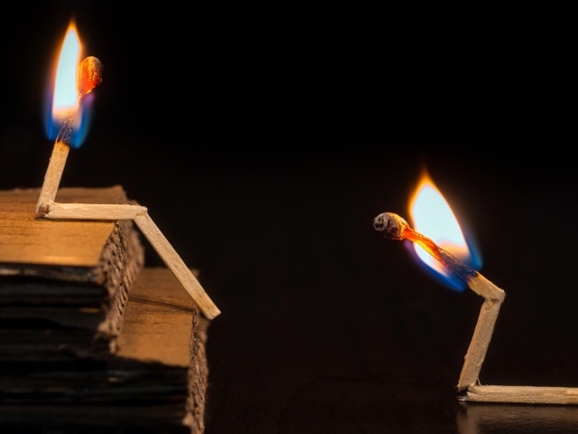 Две горящие спички на черном фоне 