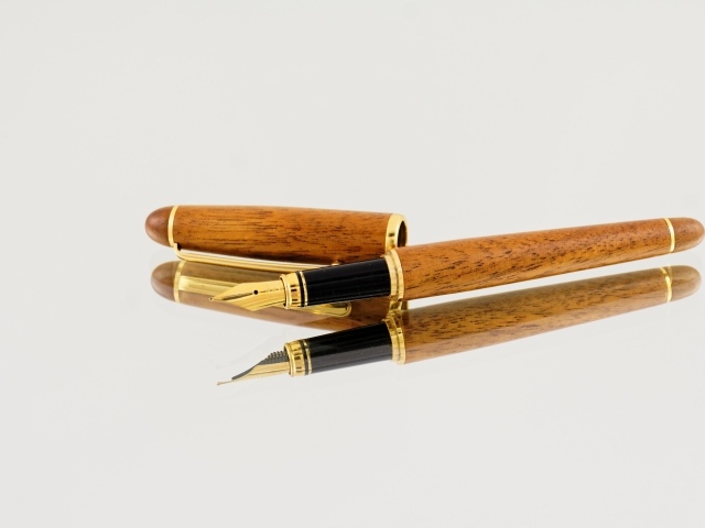 Деревянная ручка перо на сером фоне