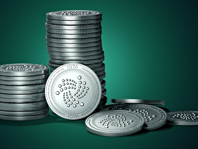 Монеты IOTA на зеленом фоне