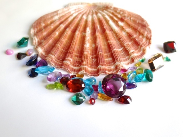 Ракушка и драгоценные камни на белом фоне