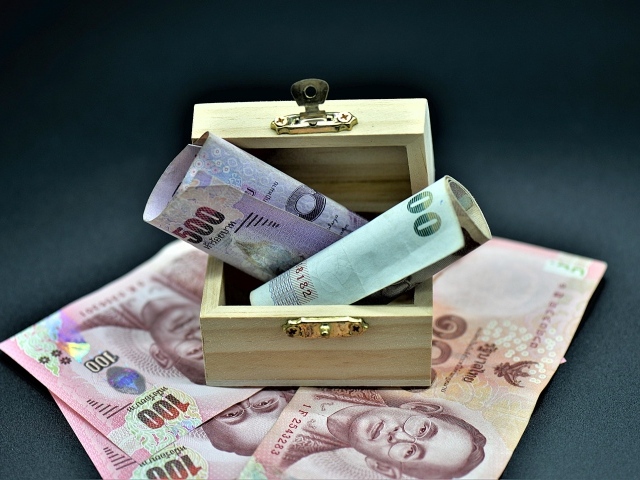 Бумажные деньги на сером фоне с деревянной шкатулкой