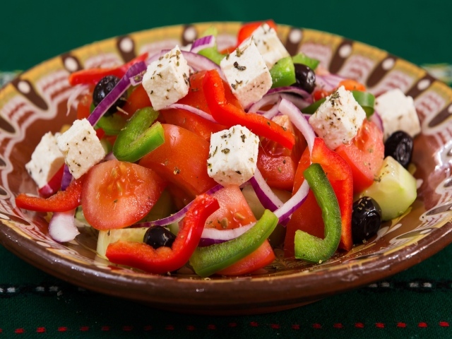 Аппетитный греческий салат в тарелке на столе
