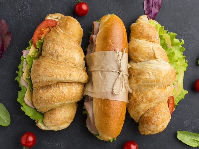 Аппетитные бутерброды на сером столе 