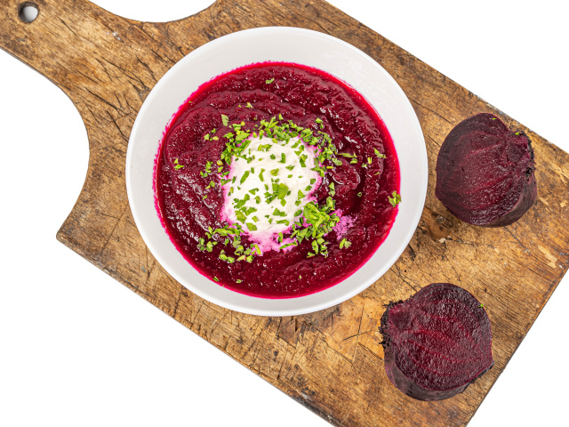 Свекольный суп в тарелке на белом фоне