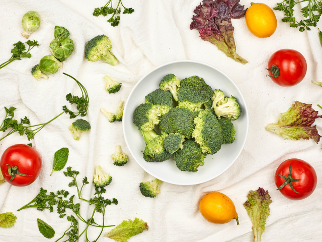 Брокколи на столе с помидорами и зеленью