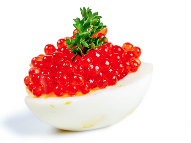 Яйцо фаршированное красной икрой на белом фоне