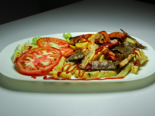 Картофель фри на тарелке с помидорами 