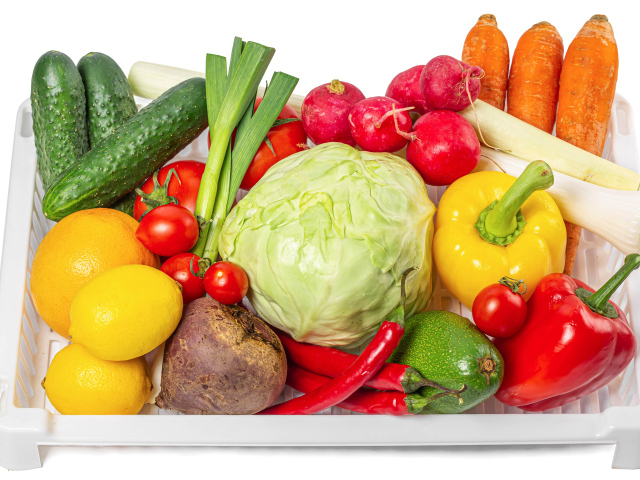Свежие аппетитные овощи в ящике на белом фоне