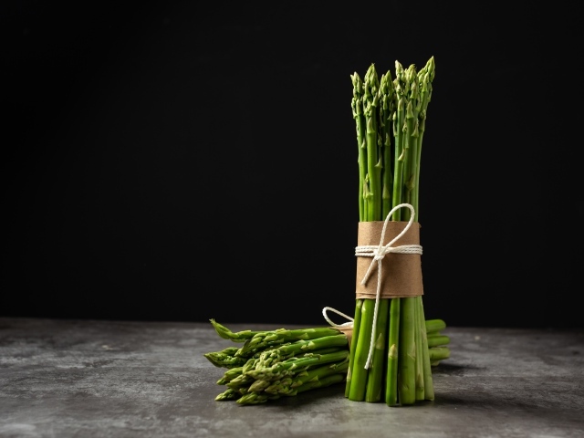 Зеленая спаржа на черном фоне 