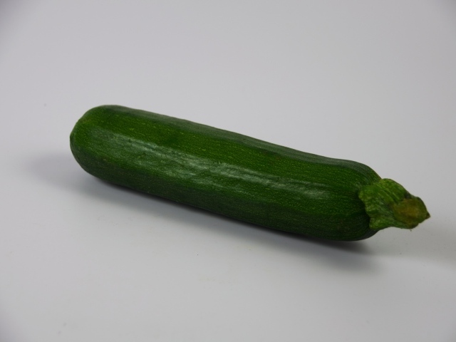 Зеленый кабачок на сером фоне