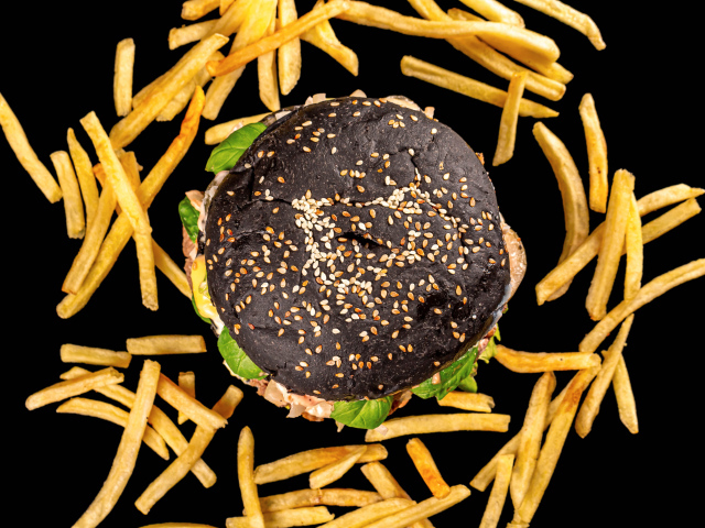 Гамбургер на черном фоне с картофелем фри