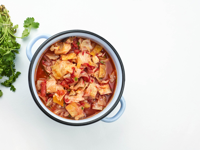 Горячие щи в кастрюле на столе с петрушкой