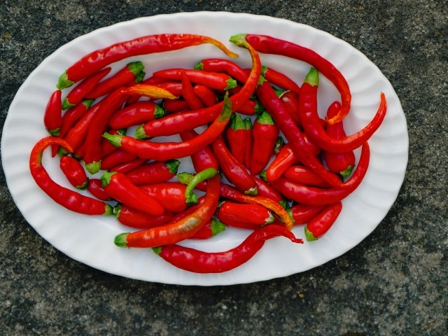 Острый красный перец чили на большой белой тарелке