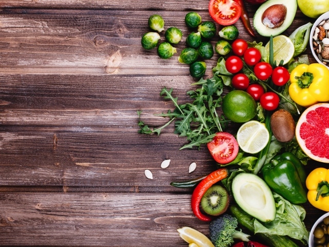 Много свежих овощей и фруктов на деревянном столе 