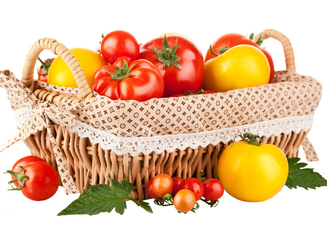 Красные и желтые помидоры в корзине на белом фоне