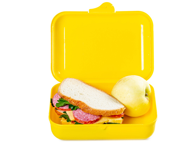 Бутерброд и яблоко в контейнере на белом фоне