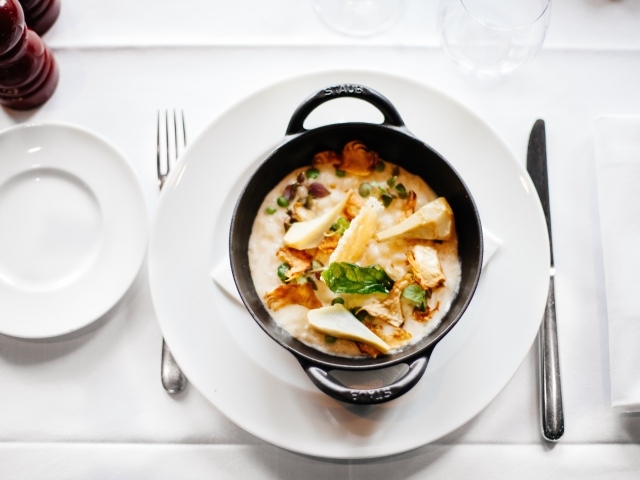 Суп в миске стоит на белой тарелке 