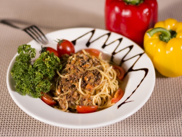 Спагетти с фаршем и помидорами в тарелке 