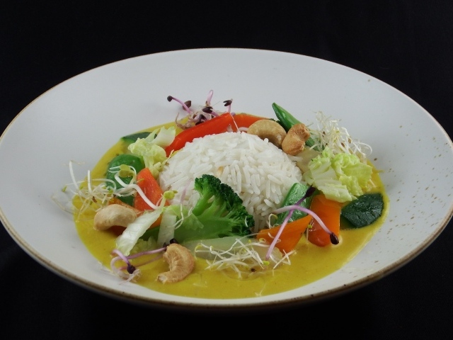 Вареный рис с овощами в большой белой тарелке