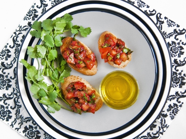 Бутерброды с помидорами на тарелке с петрушкой и маслом