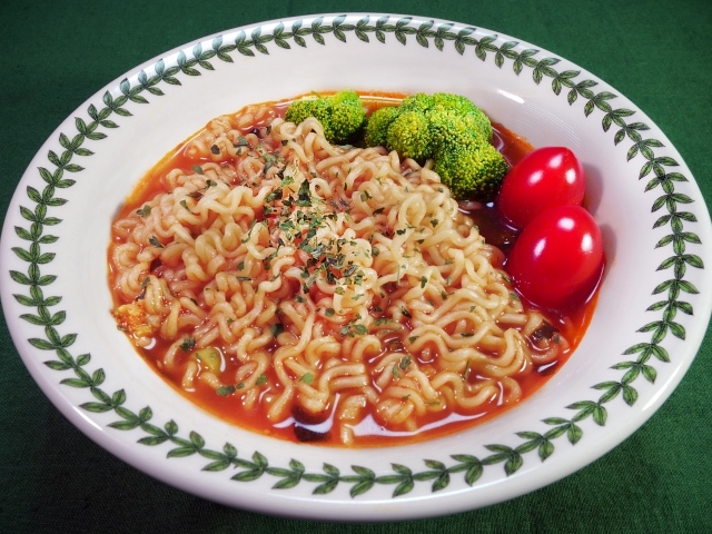 Вермишель с соусом в тарелке с помидорами