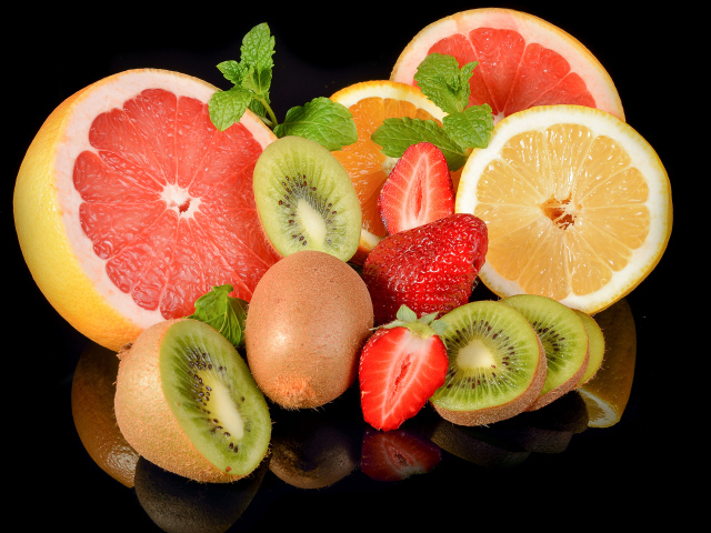 Цитрусовые фрукты с клубникой на черном фоне