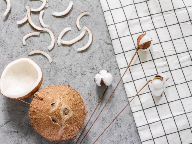 Кокос с веточками льна на столе 