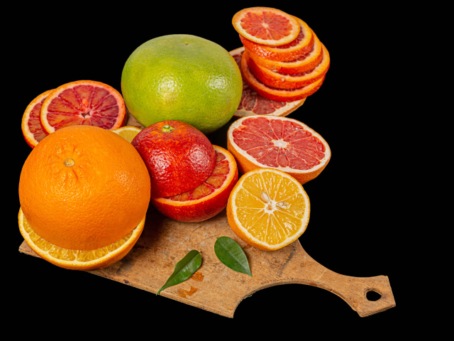 Свежие нарезанные цитрусовые фрукты на черном фоне