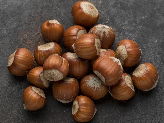 Много лесных орехов на сером столе 