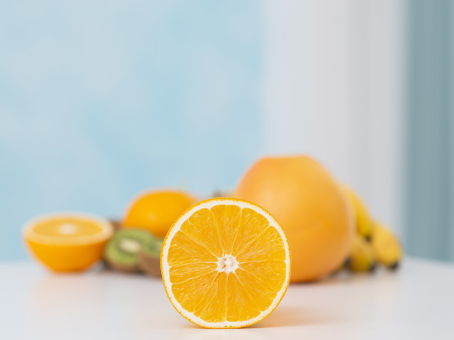 Оранжевые апельсины с киви на столе 