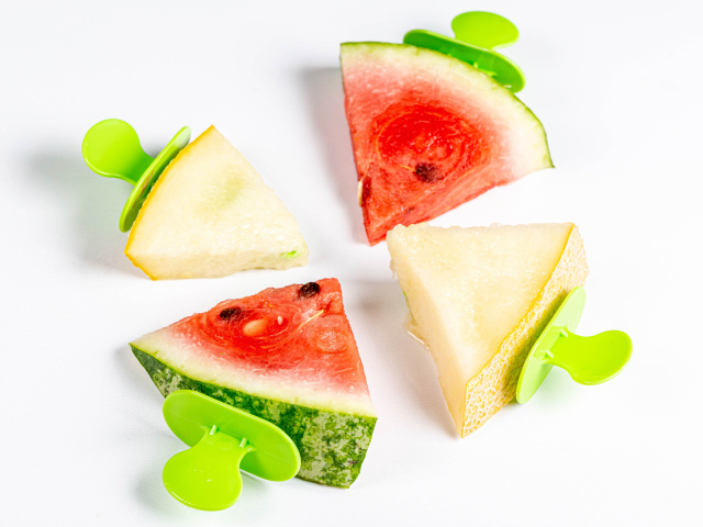 Кусочки арбуза и дыни на палочках на белом фоне