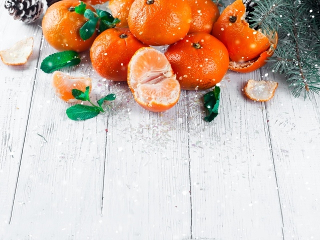 Спелые сочные мандарины с мятой на столе