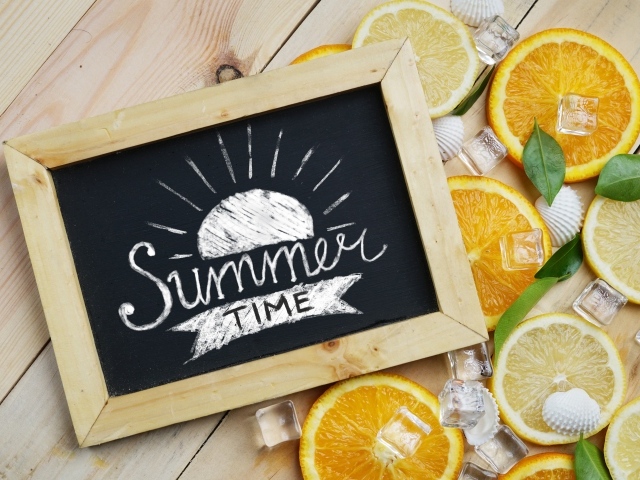 Кружочки лимона и апельсина с кубиками льда на столе с рамкой 